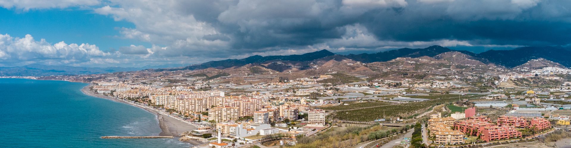 Drone perspective of costal city of Torrox situated in Malaga, Costa del Sol, Spain Drone perspective of costal city of Torrox situated in Malaga, Costa del Sol, Spain. Touristic travel destination. View of the promenade and beach area. The lighthouse of Torrox and the river.